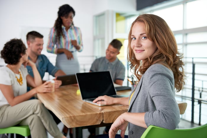 Photo of woman and her team collaborating